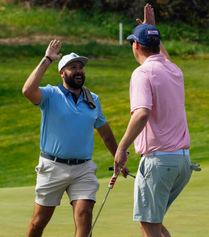 Jackson sharing a high-five with a friend on a golf course